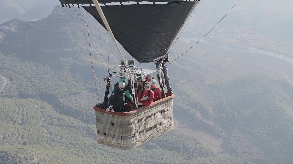 空高く舞い上がった2つの気球の間に張られた1本のロープを綱渡りするムービー Gigazine
