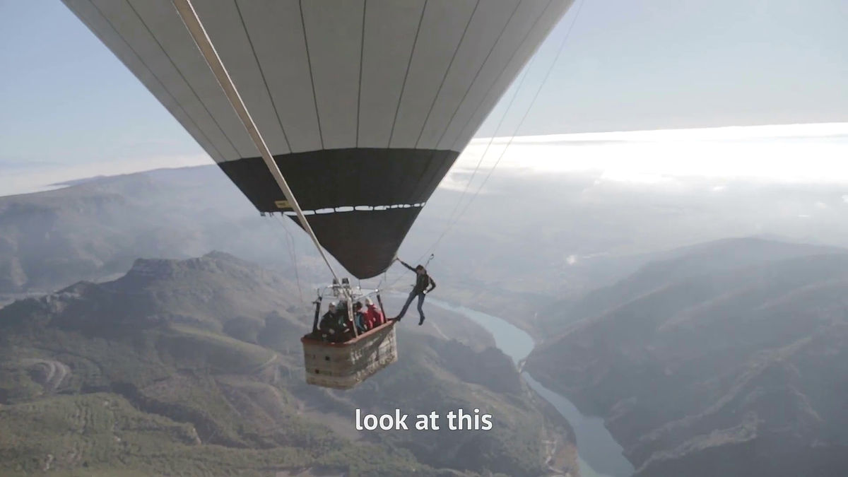 空高く舞い上がった2つの気球の間に張られた1本のロープを綱渡りするムービー Gigazine